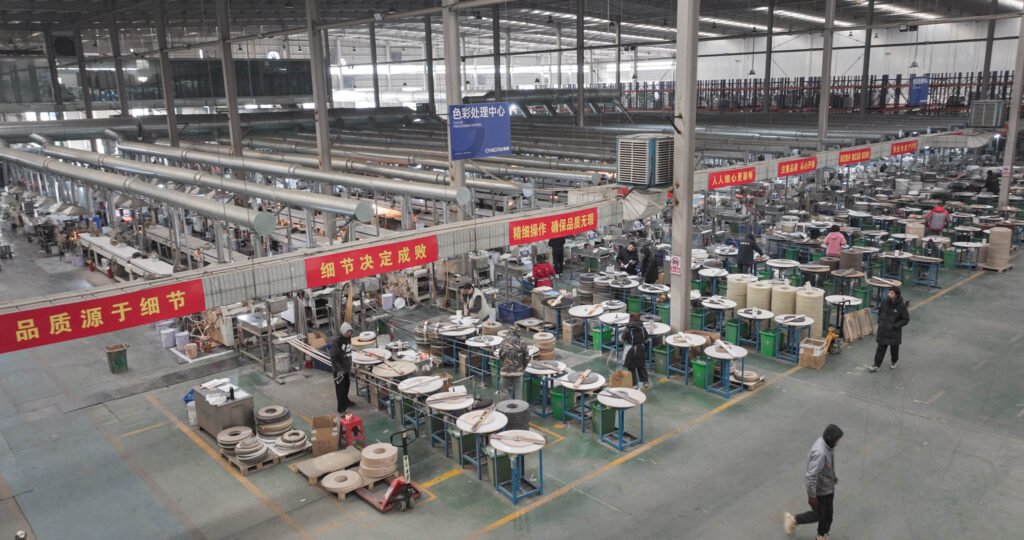 Technician operating edge banding extrusion machine in factory