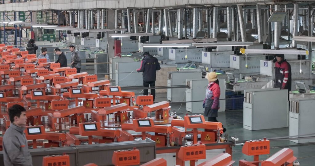 Technician operating edge banding extrusion machine in factory