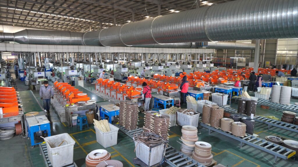 Technician operating edge banding extrusion machine in factory