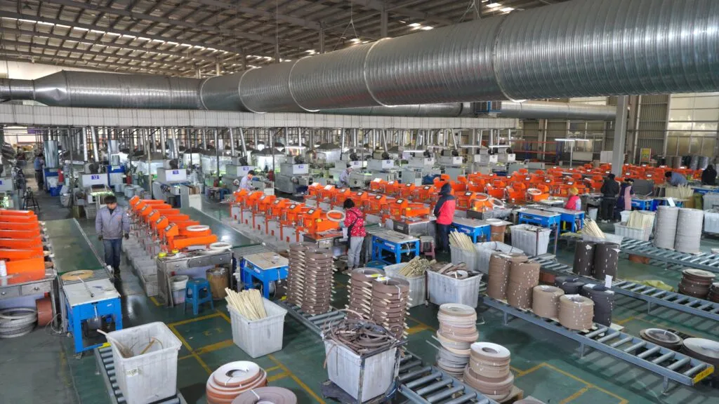 Technician operating edge banding extrusion machine in factory