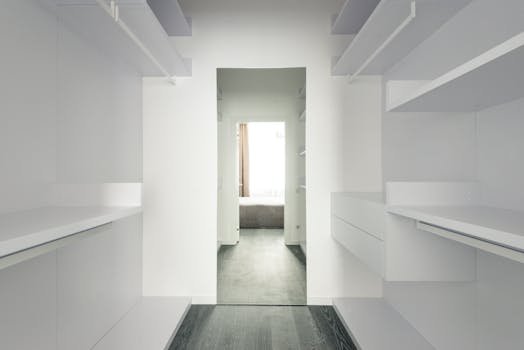 Bright and spacious modern minimalist walk-in closet with open shelving.